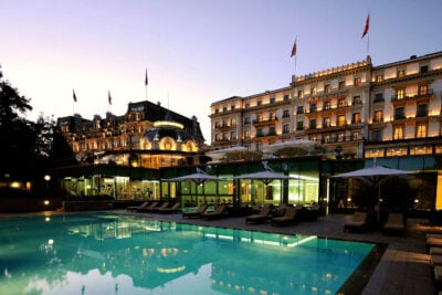A view of the pool and hotel at dusk at Beau-Rivage Palace, Switzerland