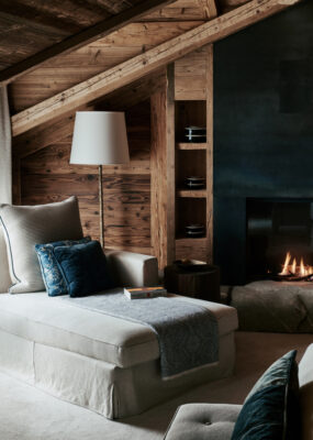 A sofa by a fire in The Alpina in Gstaad, Switzerland