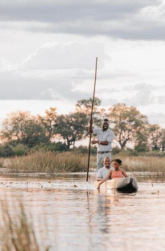 A family in a mokoro at Wilderness Vumbura Plains, Botswana