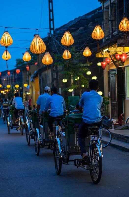 Cyclists on a street light by lanterns in Hoi An, Vietnam