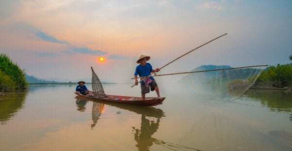 Fishermen in action when fishing in the mekong river , Thailand.