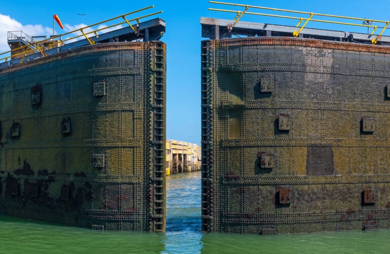 A huge metal lock gate swinging open on the Panama Canal