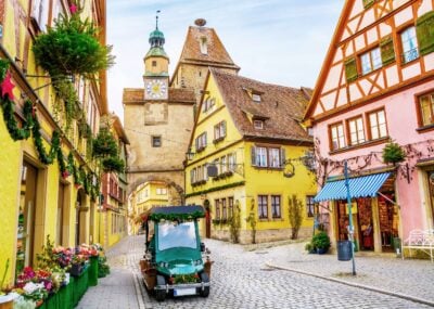 Touristic retro car on picturesque street, decorated for Christmas holiday in Rothenburg ob der Tauber, picturesque medieval historic town in Bavaria, Germany