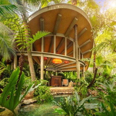 Exterior shot of hotel spa building - a large circular building with wooden front desk and chairs