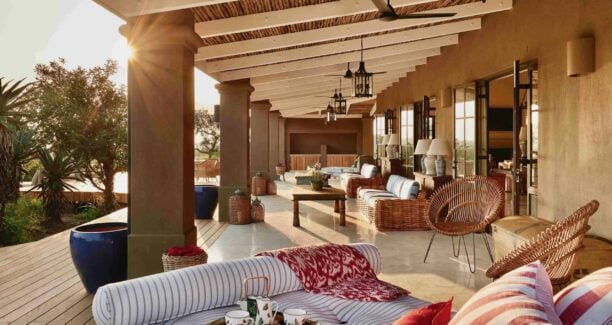 Covered veranda with comfortable sofas and chairs under a wooden canopy