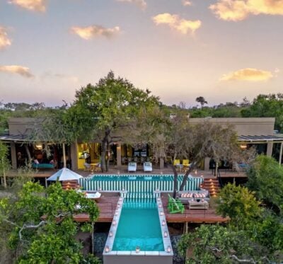 Aerial view of hotel with infinity edge pools and green foliage