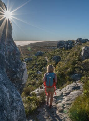 Young woman in Cape Town on top of mountain looking at view