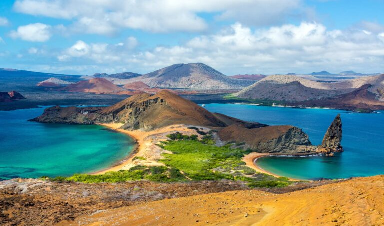 A view of sandy and rocky mountains and clear blue sea in the Galapagos Islands