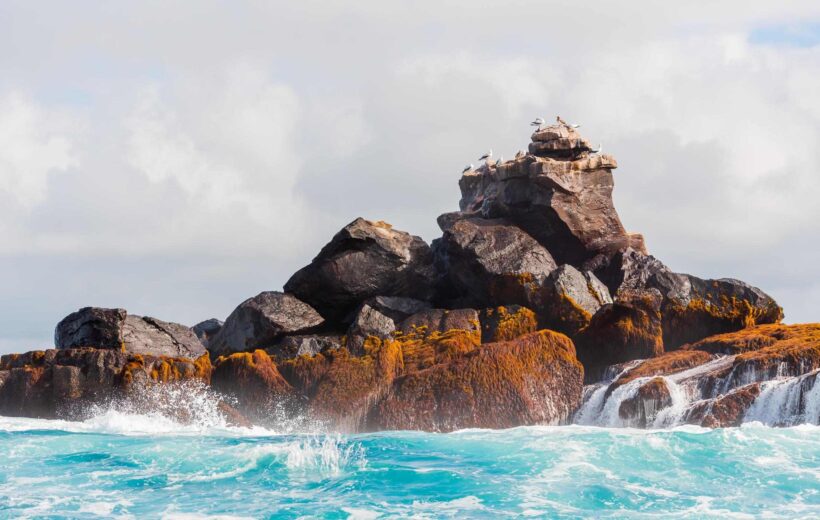 Rock in the ocean on a background of the cloudy sky, Galapagos Island, Isla Isabela.