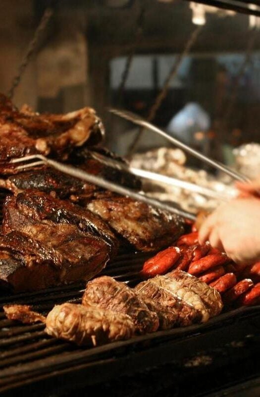 A chef in Argentina grilling cuts of steak