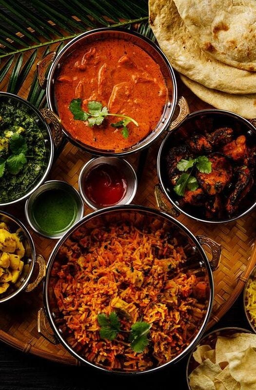 A selection of different Indian dishes with naan bread