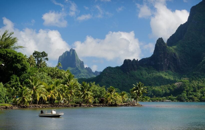 A lush green landscape surrounded by ocean in Bora Bora