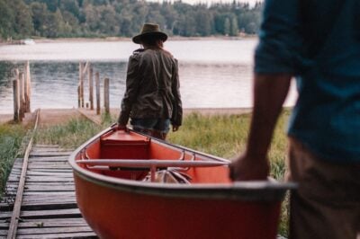 A couple carrying a rowing boat to the lake at Las Balsas hotel in Argentina