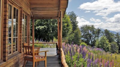 An outdoor terrace overlooking flowers, fields and mountains at Mallin Colorado, Chile