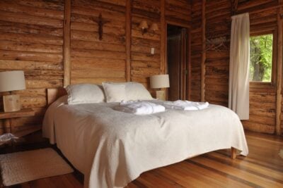 A bedroom in a log cabin at Mallín Colorado, Chile