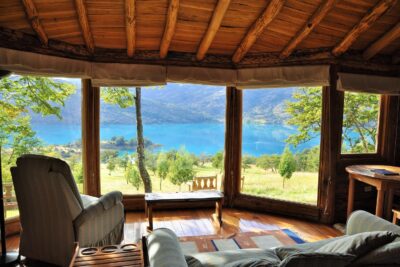 A log cabin with views of a lake through the window at Mallín Colorado, Chile