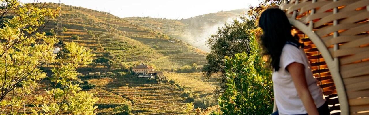 Woman looks out to Portuguese vineyards in Douro Valley