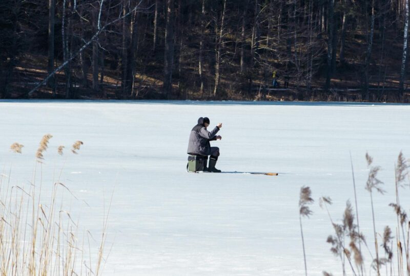 Fisherman fishing on a frozen lake in Finnish Lapland