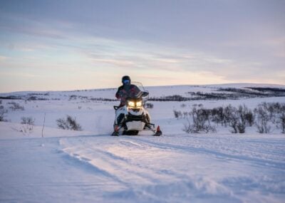 A snowmobile riding across the snow