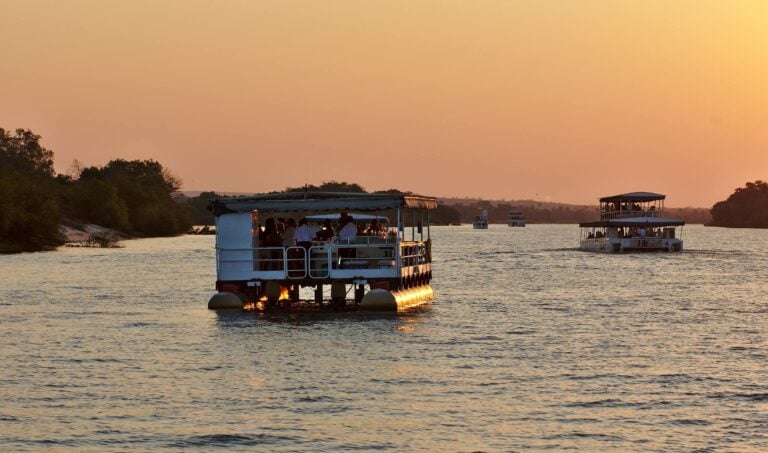 A safari ship cruising the Zambezi river at sunset