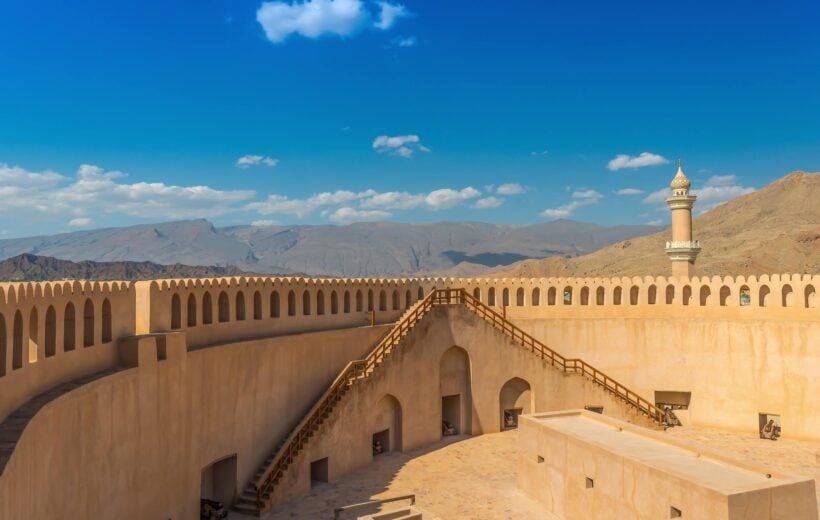 A view of Nizwa fort in Oman with mountains in the background