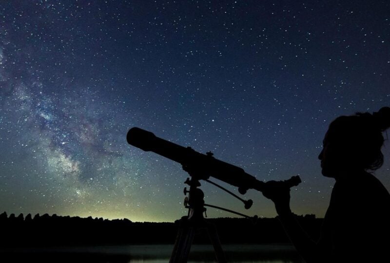 Woman with telescope watching the stars