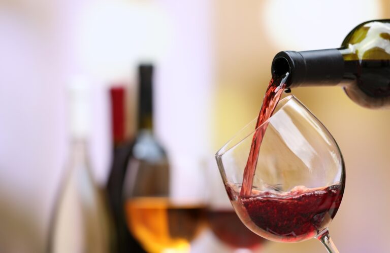 Red wine pouring into wine glass, close-up