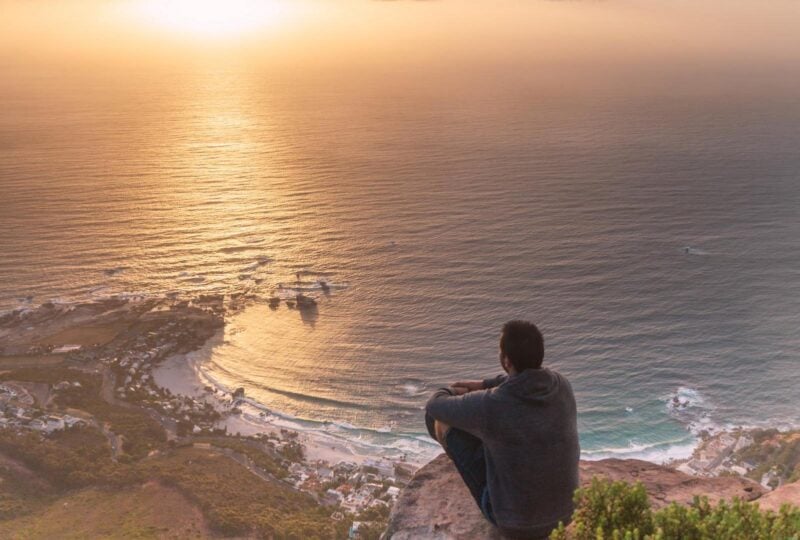 A man sitting at a viewpoint on the Lion's Head hike in Cape Town