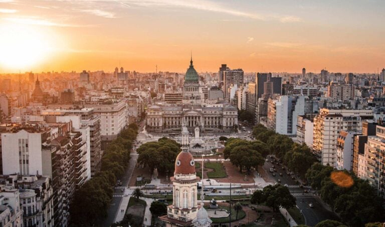 Aerial view of Buenos Aires cityscape at sunset with Congress building in focus.