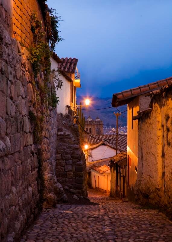 A street lit up in the evening in Cusco, Peru