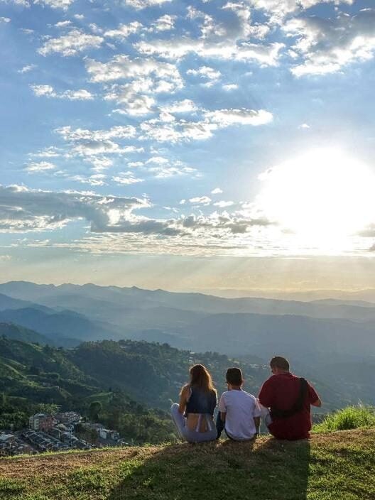 A family enjoy a sunset over a beautiful natural valley