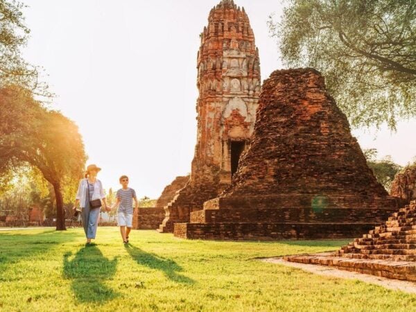 Mother and son tourists walking hand in hand in atcient Wat Chaiwatthanaram Buddhist temple ruines in holy city Ayutthaya, Thailand in Auyttaya ancient, architecture, asia, asian, ayutthaya, boy, buddha, buddhism, buddhist, budha, caucasian, child, childhood, family, female, grass, hand, hand in hand, happiness, happy, kid, landmark, landscape, mom, mother, mother and son, outdoor, outdoors, pagoda, parent, parenting, parents, people, relationship, ruin, sightseeing, son, stupa, sunlight, sunset, temple, thailand, together, tourism, tourist, travel, traveler, vacation, walking, woman