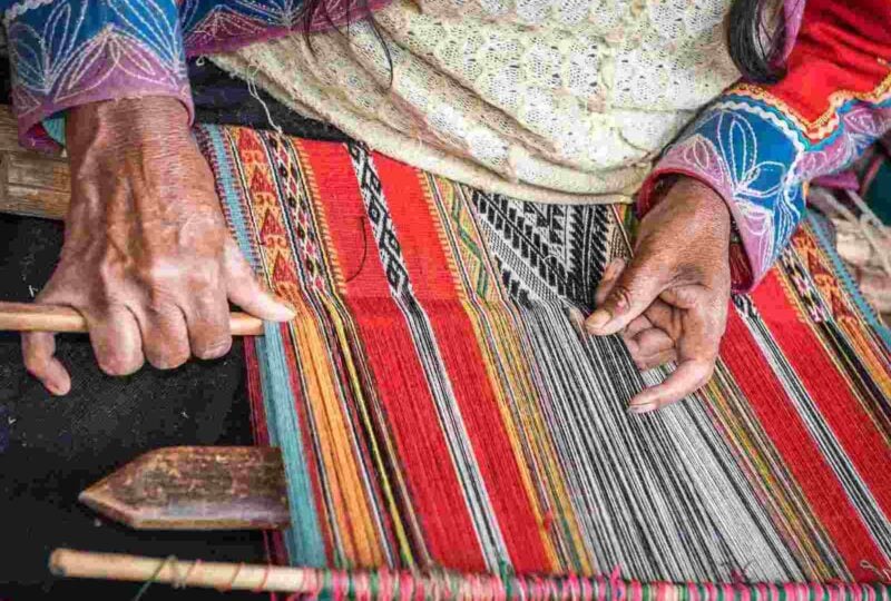 Hands of Peruvian weaver making a striped textile