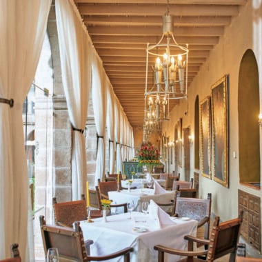 Corridor filled with dining tables and chairs at Belmond Hotel Monasterio, Peru