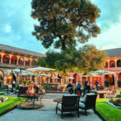 A garden with outdoor seating and a central fountain in Belmond Hotel Monasterio, Peru