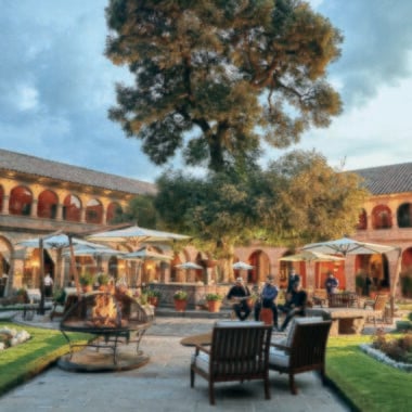 A garden with outdoor seating and a central fountain in Belmond Hotel Monasterio, Peru