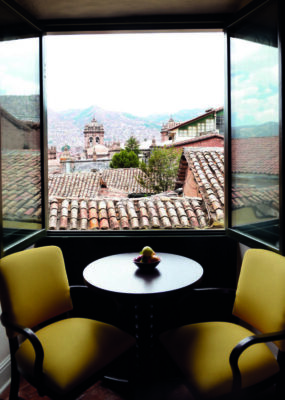 Two chairs set up by a window with a view over Cusco at Belmond Hotel Monasterio, Peru