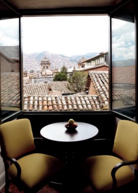 Two chairs set up by a window with a view over Cusco at Belmond Hotel Monasterio, Peru